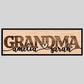 A custom laser-cut wooden sign with the word 'GRANDMA' in bold letters and two names, 'amelia' and 'sarah', personalized on the sign's surface.